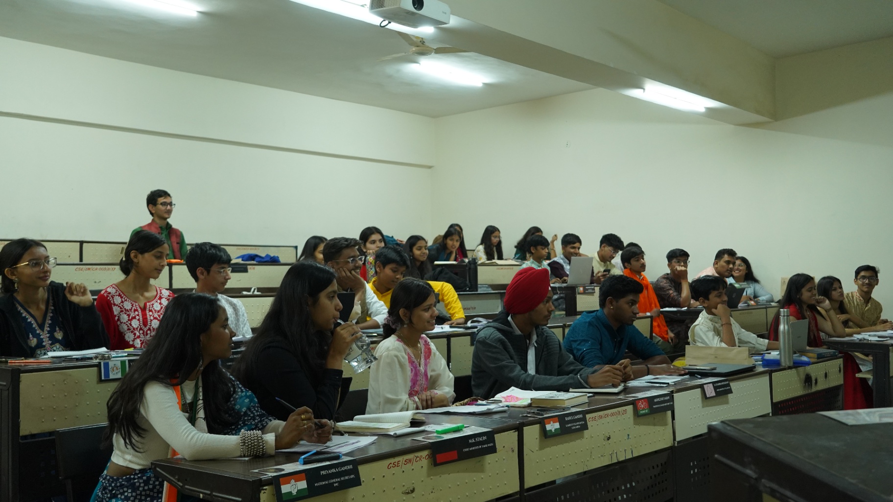 Rows of TMF delegates focused during a committee debate.