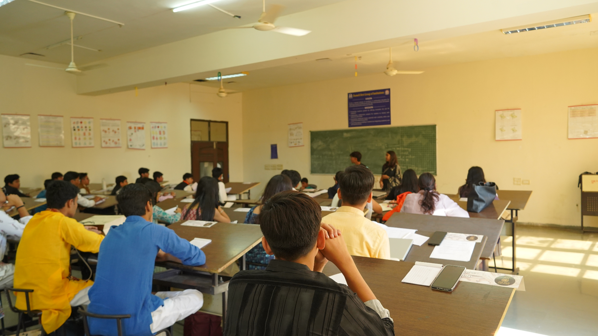 Students attending a daytime TMF classroom workshop under warm sunlight.