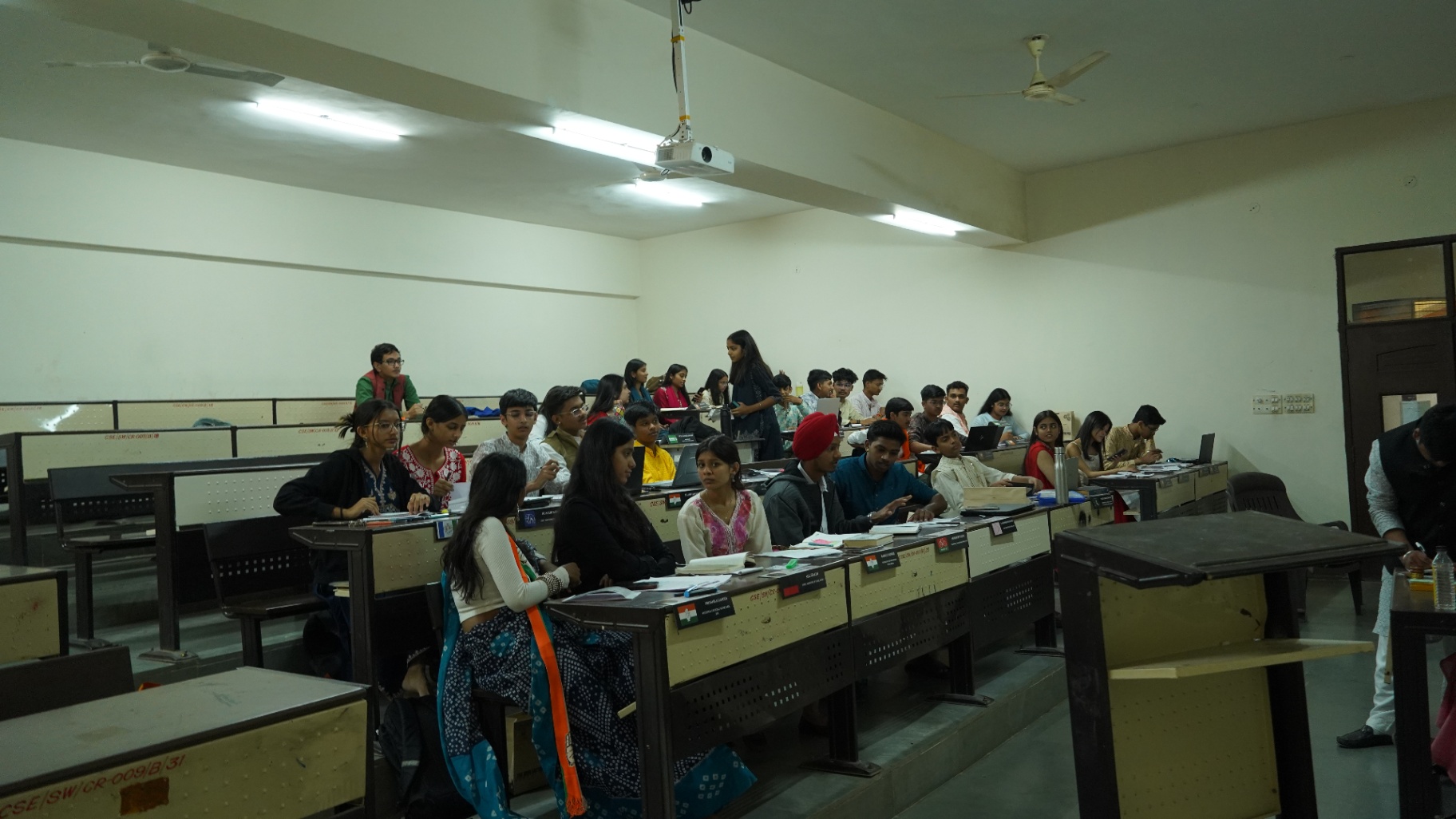 Delegates seated in a tiered lecture hall during a TMF committee session.
