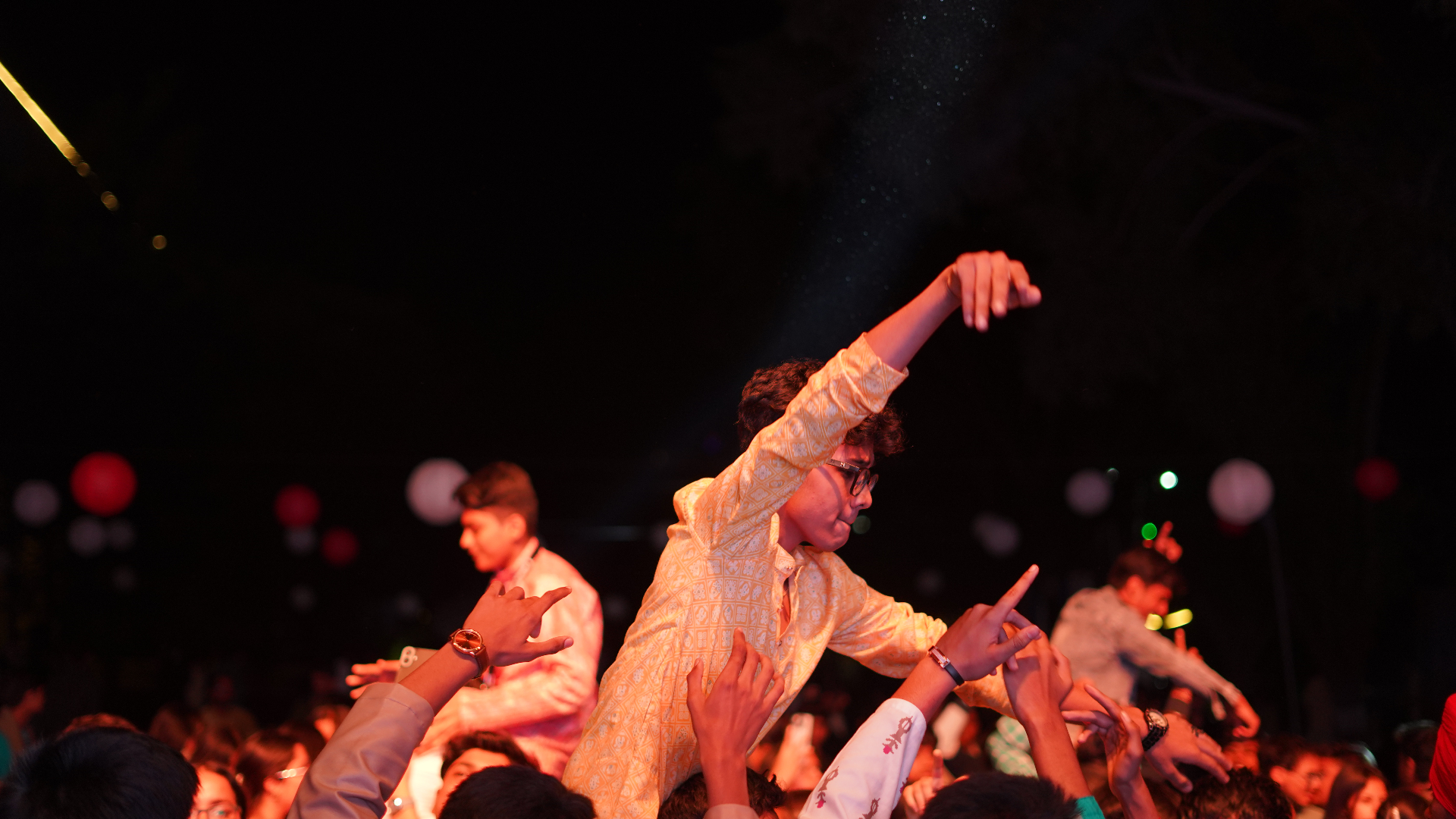 TMF students celebrating under concert lighting at a live youth event.